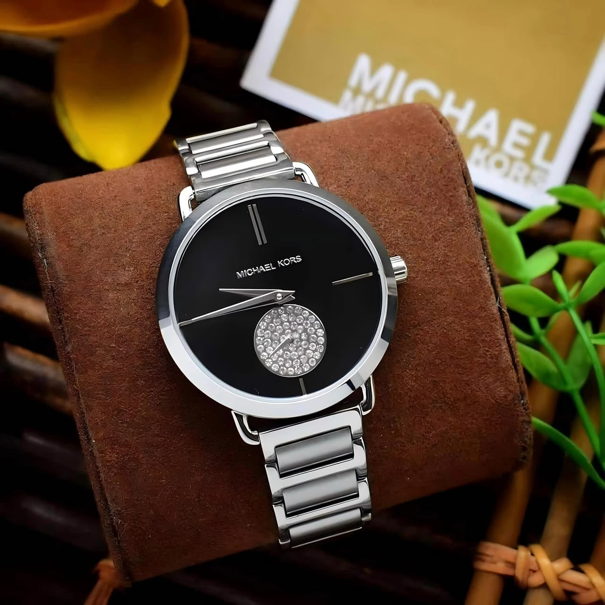 Michael Kors Portia MK3638 silver-tone watch with black dial on a brown display pillow