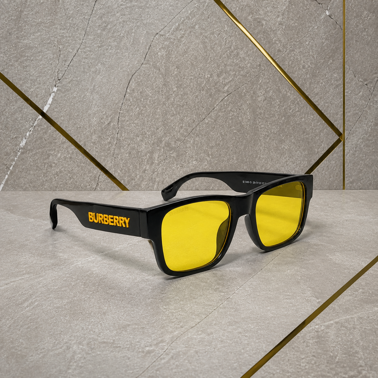 Burberry yellow-lens sunglasses against the grey PrimePicks office wall