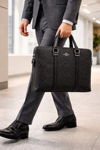 Coach black signature laptop bag carried by a model