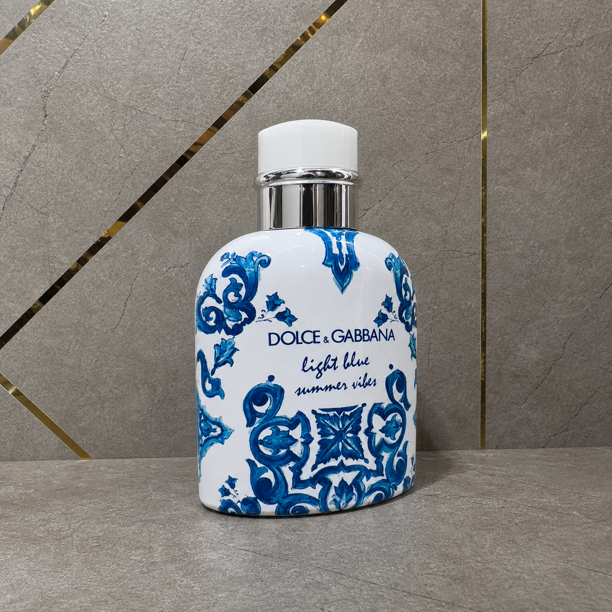 Dolce & Gabbana Light Blue Summer Vibes Pour Homme bottle against the PrimePicks stone wall