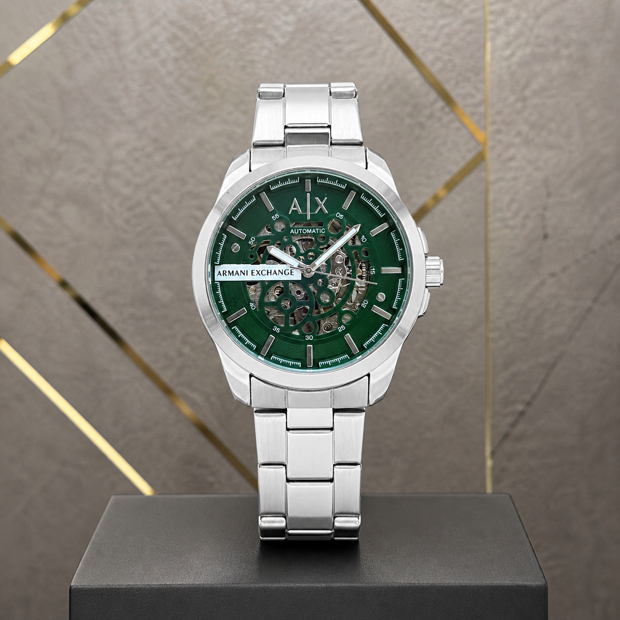 Armani Exchange Hampton green skeleton watch against gray and gold office wall