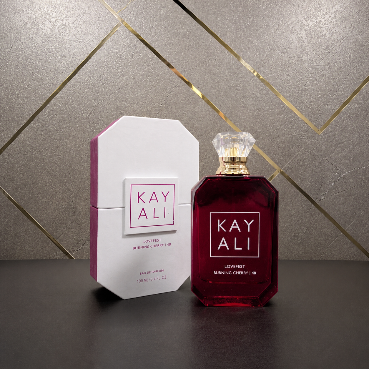 Kayali Lovefest Burning Cherry | 48 Eau de Parfum 100ml with box on stone and gold office wall