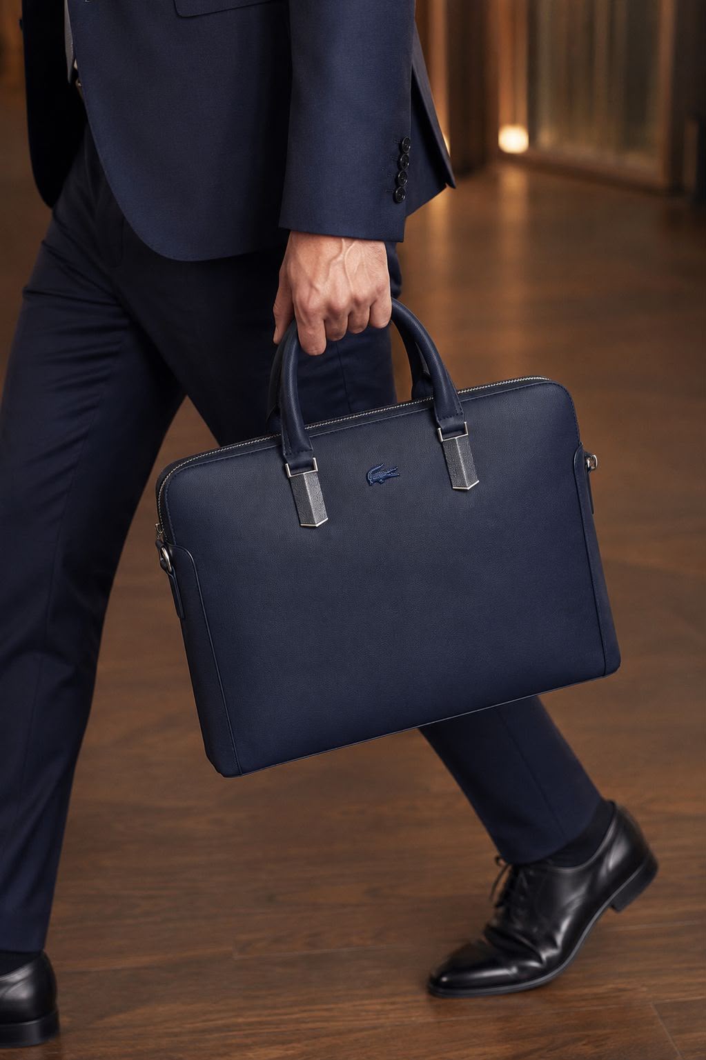 Navy Blue Lacoste laptop bag carried with business attire