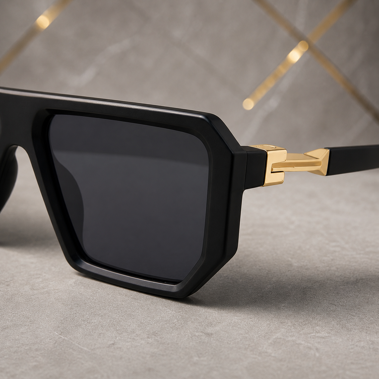 Marc Jacobs matte black angular square sunglasses with gold-tone hinges and dark smoke lenses, geometric hinge detail