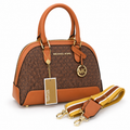Michael Kors Alma signature MK monogram handbag with broad shoulder belt on a white background