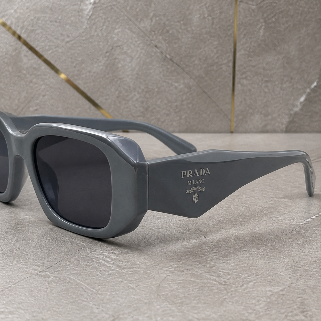Prada Milano angular rectangular sunglasses in slate grey, faceted frame and temple detail