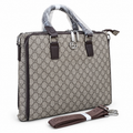 Gucci-marked taupe-grey monogram office bag with brown handles and detachable strap; edited white-background image