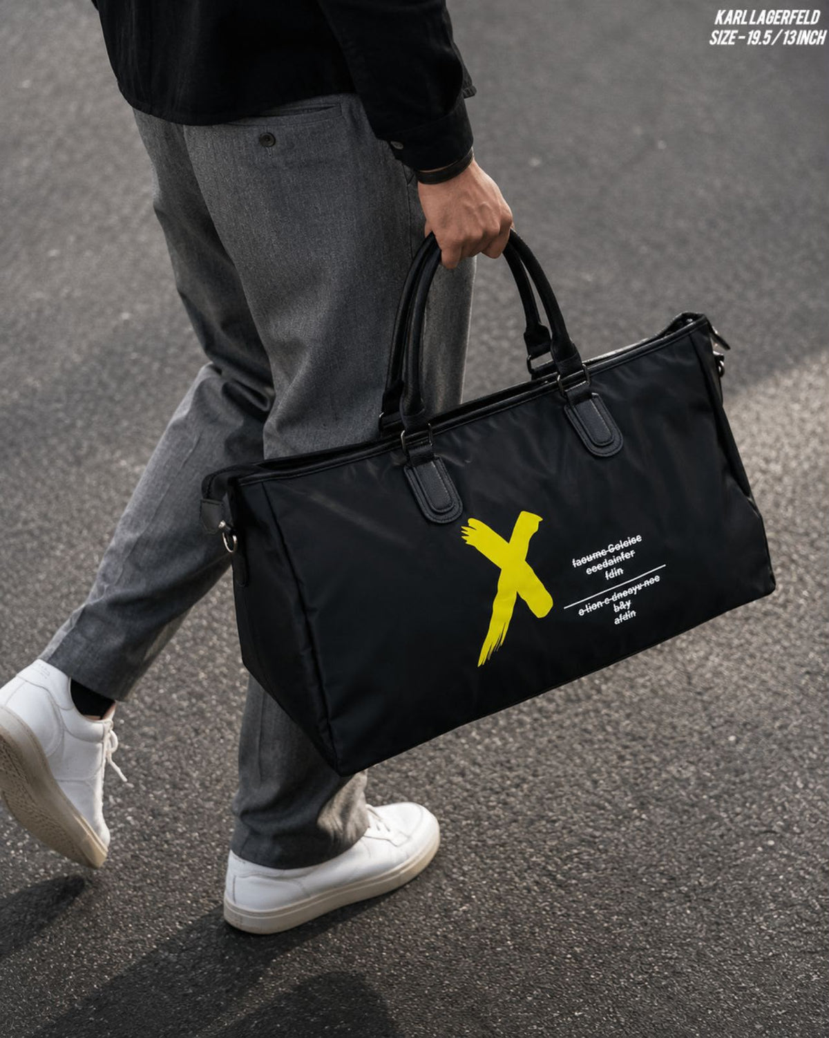 Supplier lifestyle photograph of the black duffel bag carried by hand