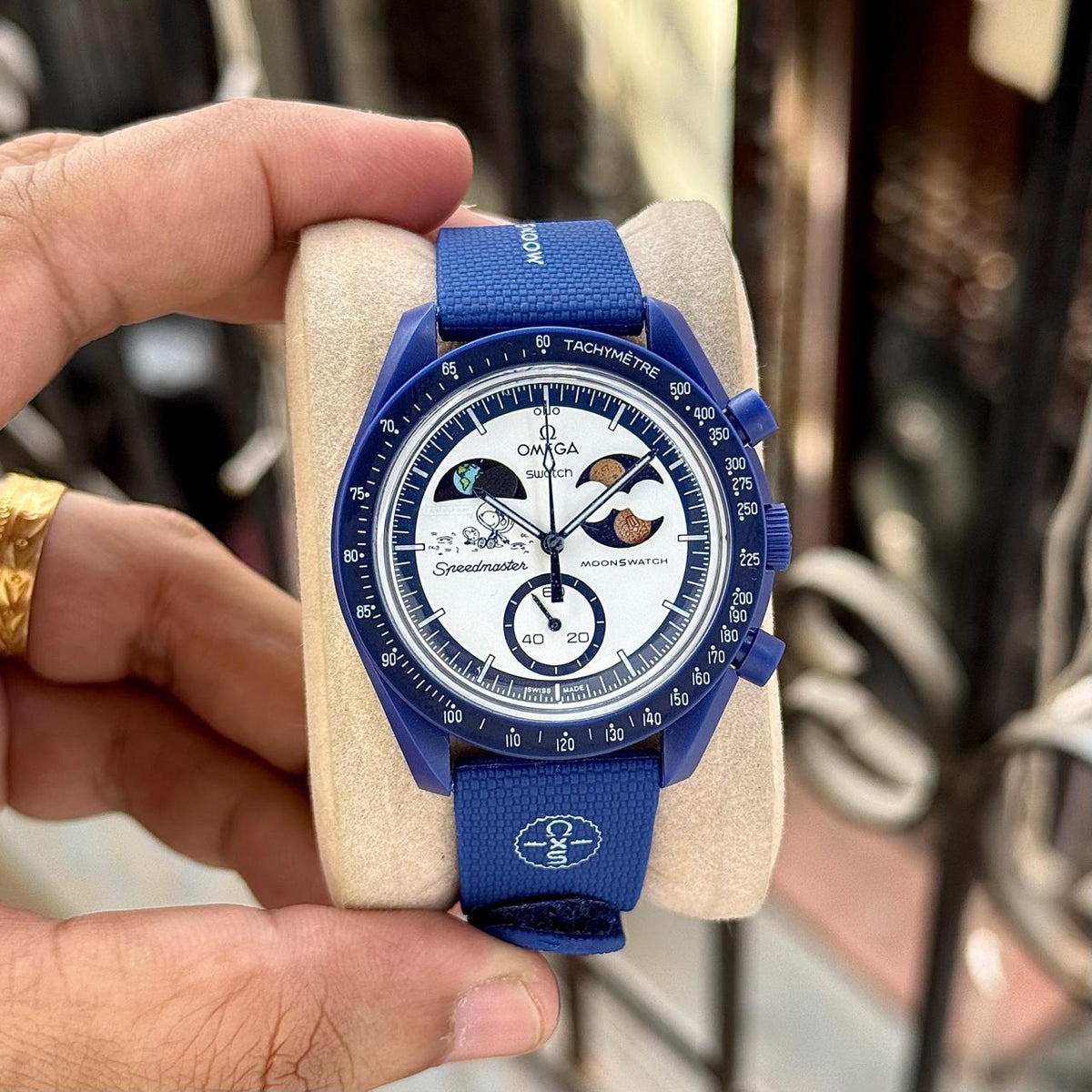 Front view of the navy Omega x Swatch MoonSwatch Mission to Earthphase replica watch on a display cushion