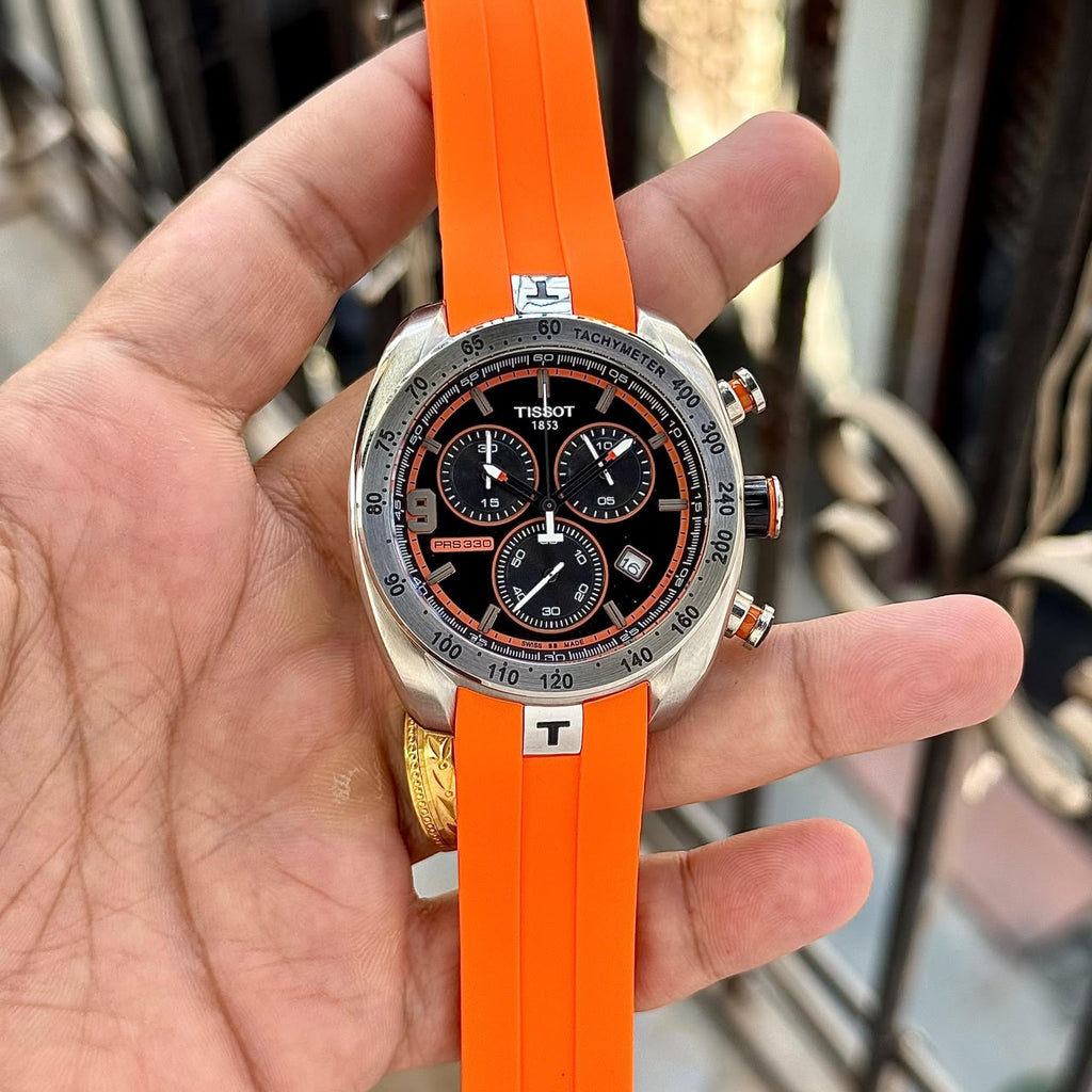 Close-up of Tissot PRS 330 chronograph watch with orange strap