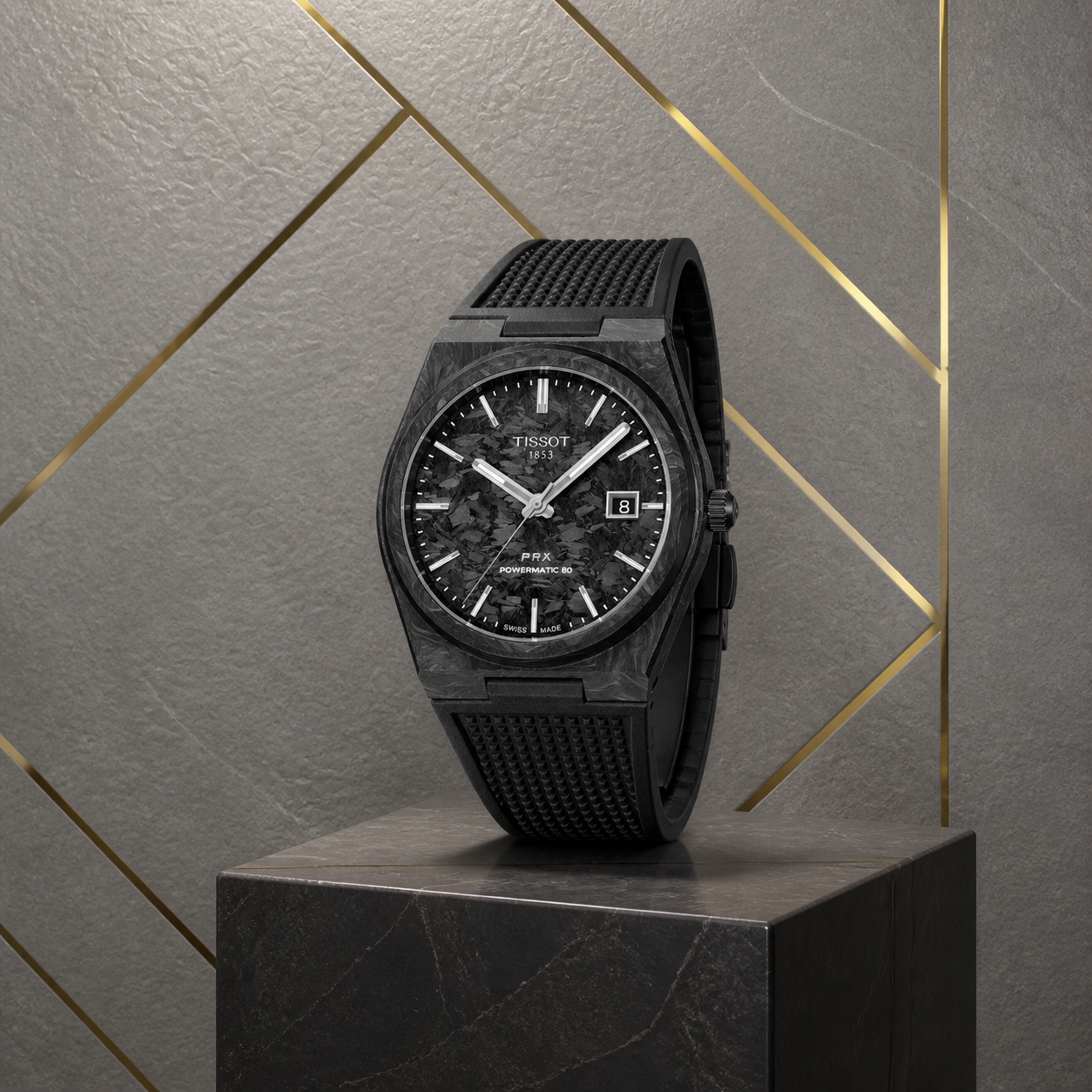 Tissot PRX Powermatic 80 Carbon Black watch three-quarter view on grey and gold office wall