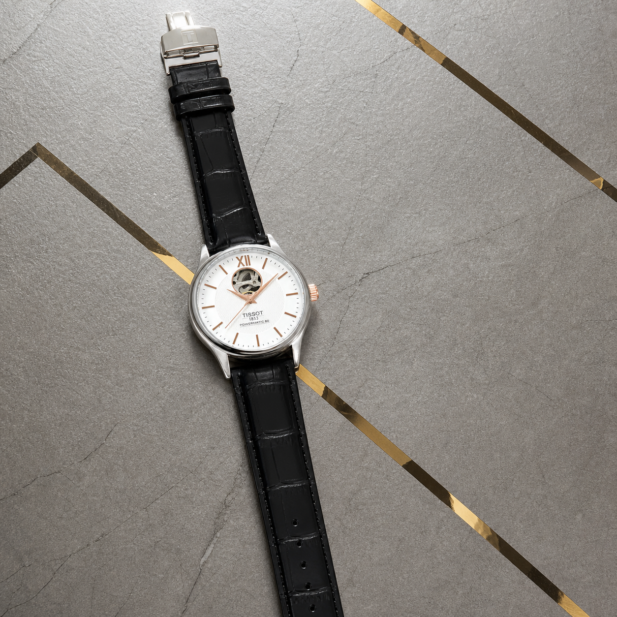Tissot Tradition Powermatic 80 full watch on Primepicks gold-inlay office wall