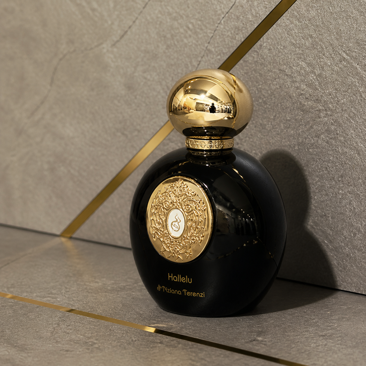 Tiziana Terenzi Comete glossy black perfume bottle with ornate gold medallion close-up