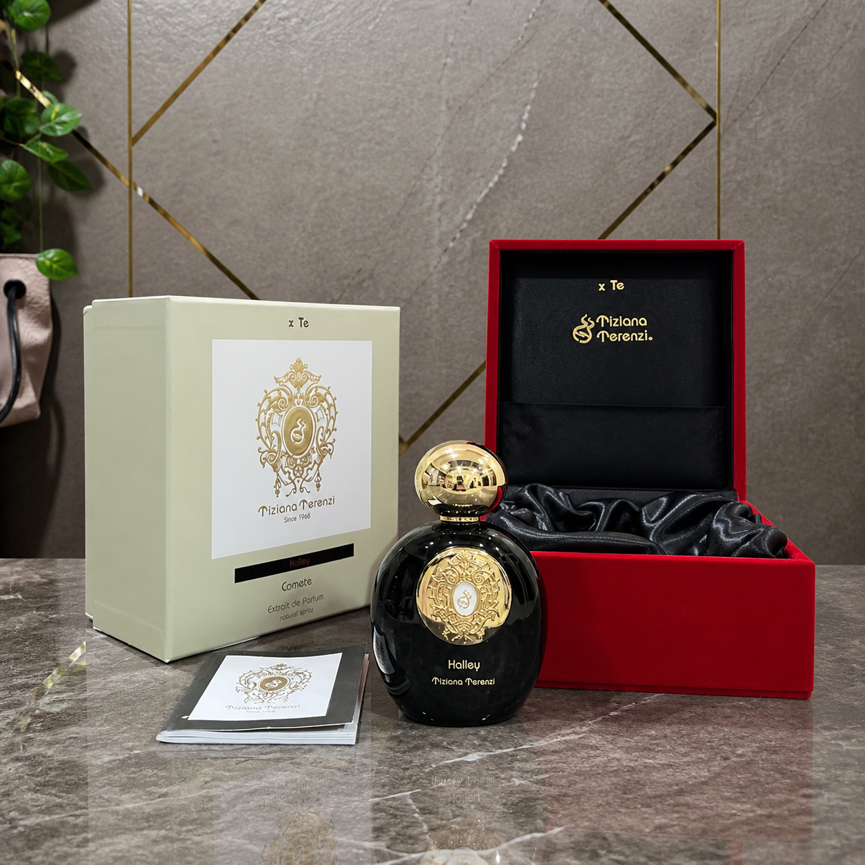 Tiziana Terenzi Comete perfume bottle and luxury gift box on gold-accent office wall