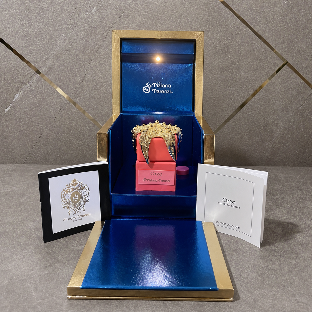 Tiziana Terenzi Orza Extrait de Parfum against the PrimePicks grey stone and gold wall