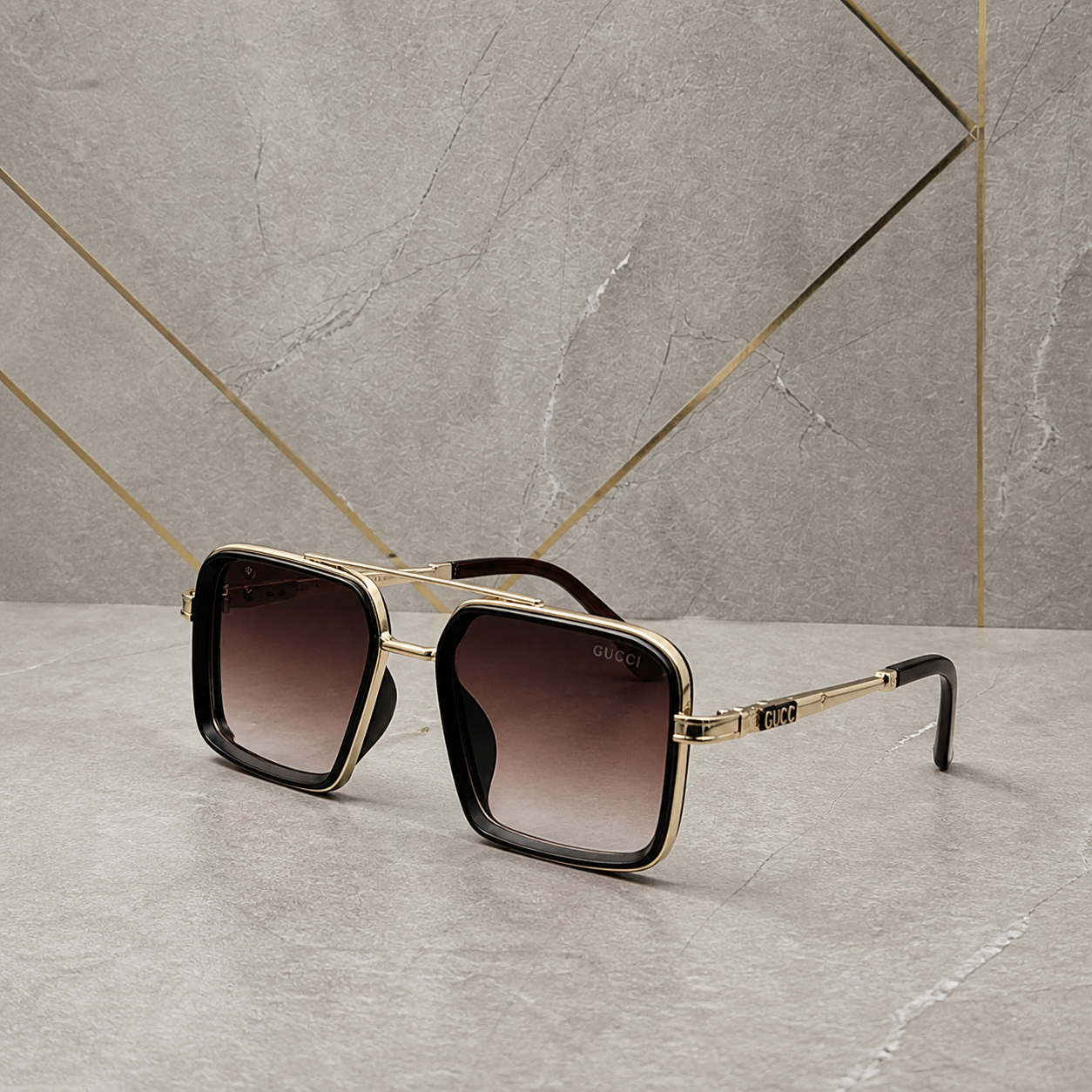 Gucci gold-and-black square double-bridge sunglasses with brown gradient lenses, front three-quarter hero view