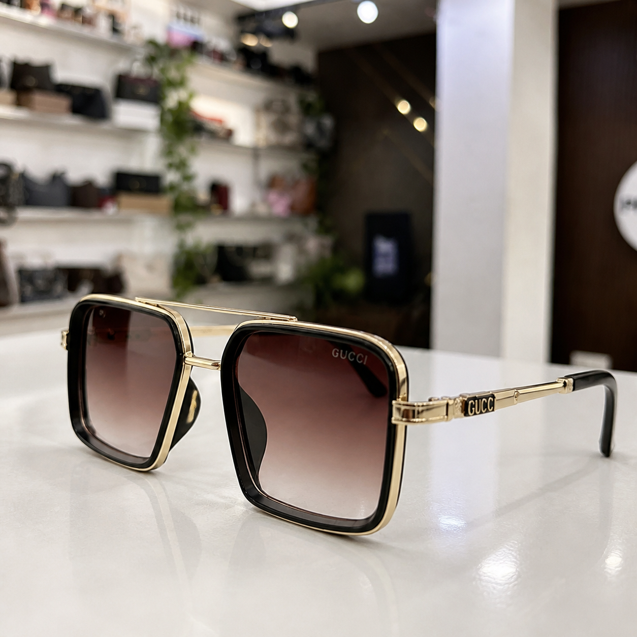 Gucci gold-and-black square double-bridge sunglasses with brown gradient lenses, temple plaque and hinge detail