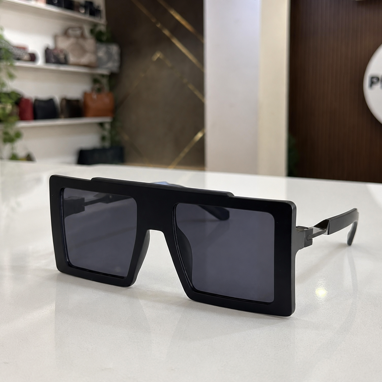 Marc Jacobs matte black oversized flat-top rectangular sunglasses with dark smoke lenses, PrimePicks office lifestyle view