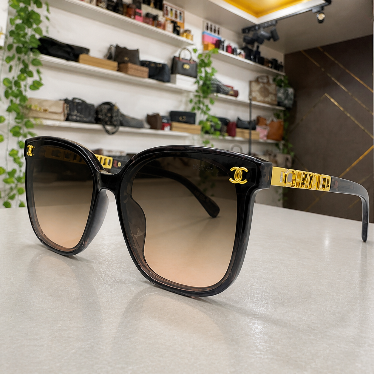 Chanel smoke-grey butterfly sunglasses with brown gradient lenses, gold-tone emblem and hinge detail