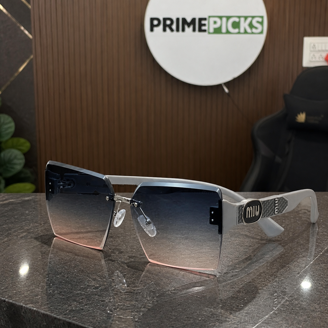 Miu Miu light grey-temple oversized rimless square sunglasses with silver-tone hardware and blue-grey-to-rose gradient lenses, PrimePicks office lifestyle view