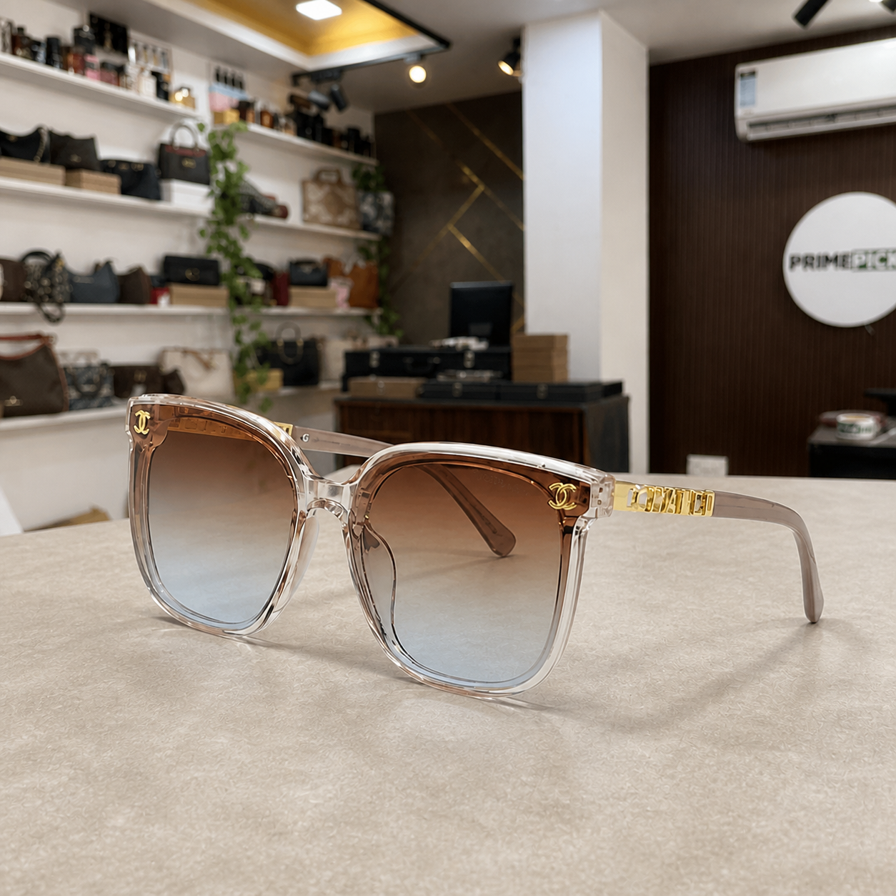 Chanel crystal-blush butterfly sunglasses with brown gradient lenses, PrimePicks office lifestyle view